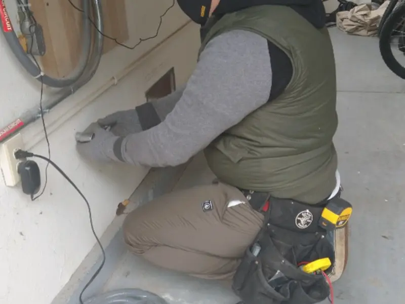 Electrician performing outlet wiring in a Ulysses garage